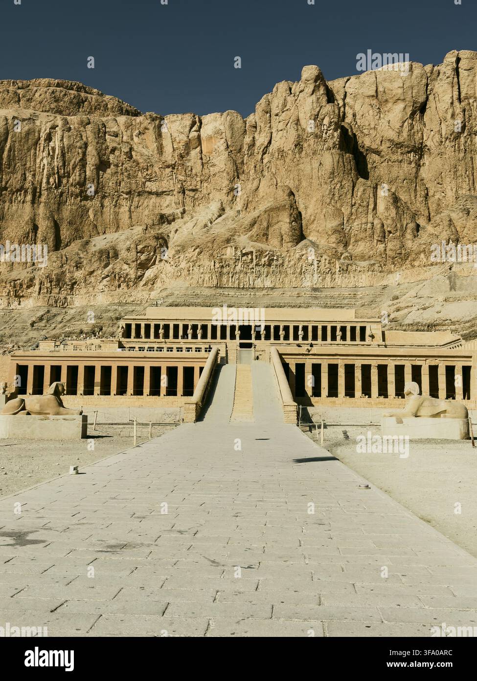 Vue du temple funéraire de Hatchepsout avec ses colonnades emblématiques et ses rampes de pierre, niché contre les falaises de calcaire dramatiques de Deir el-Bahari, Égypte Banque D'Images