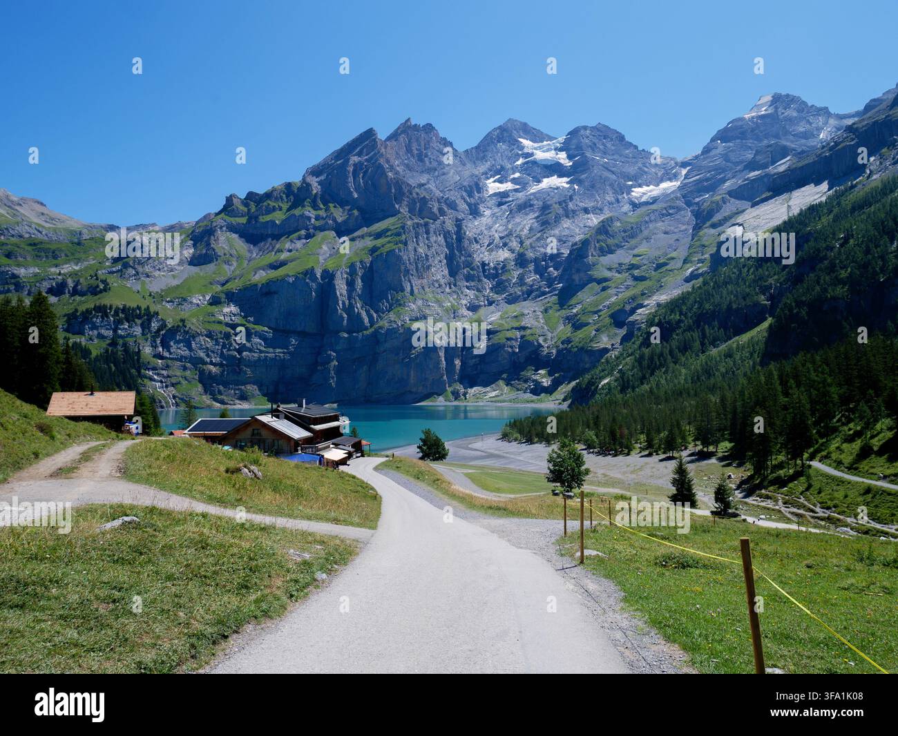 Sentier de montagne pittoresque menant à un lac alpin turquoise et à des chalets en bois, destination de vacances, tourisme en Suisse Banque D'Images