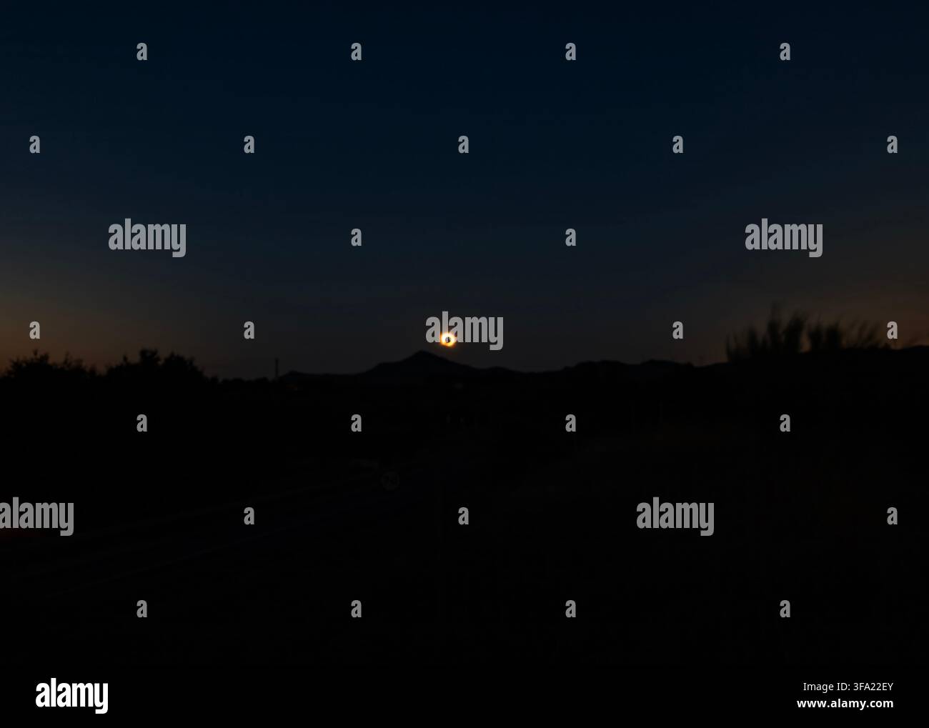 Astronomie et Nature : Silhouette des montagnes et de la route pendant la totalité d'une éclipse solaire totale bas sur l'horizon en Catalogne, Espagne Banque D'Images