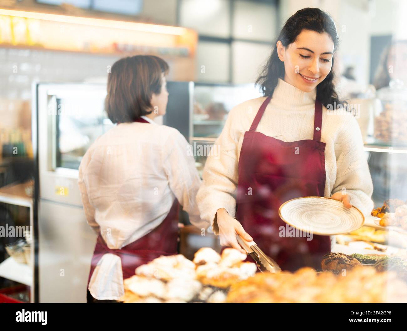 Fille vendeuse travaille dans la boutique de boulangerie cafétéria Banque D'Images