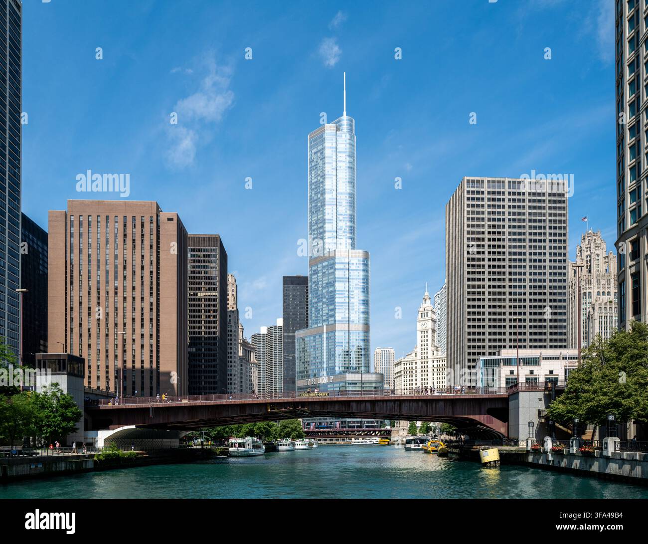 L’hôtel et la tour Trump International s’élevant le long de la rivière Chicago avec des ponts urbains et des gratte-ciel du centre-ville sous un ciel bleu clair. Banque D'Images