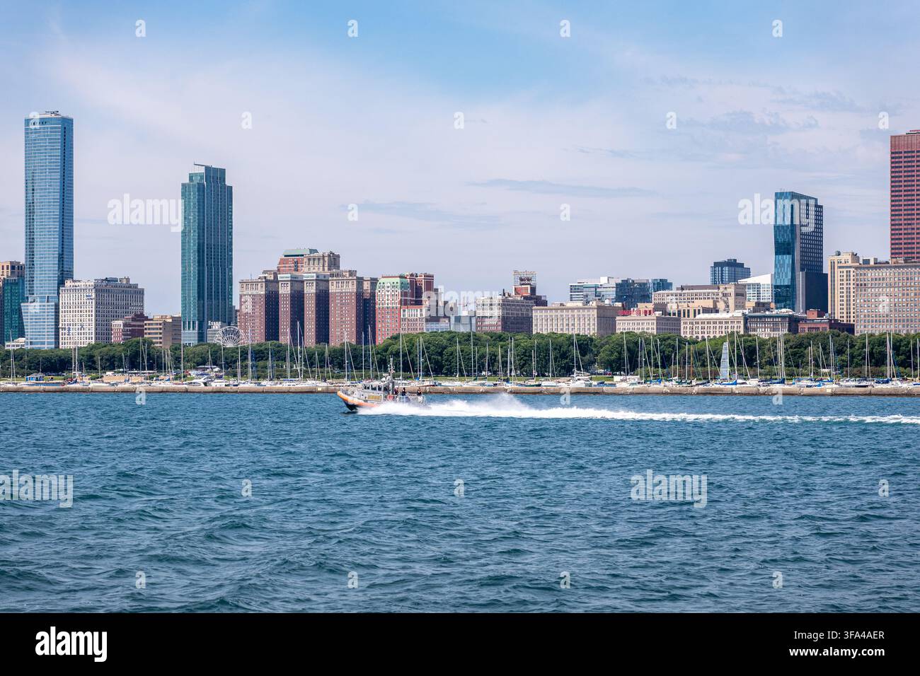 Bateau de patrouille des U.S. Coast Guard filant sur le lac Michigan avec la skyline de South Loop à Chicago. Banque D'Images