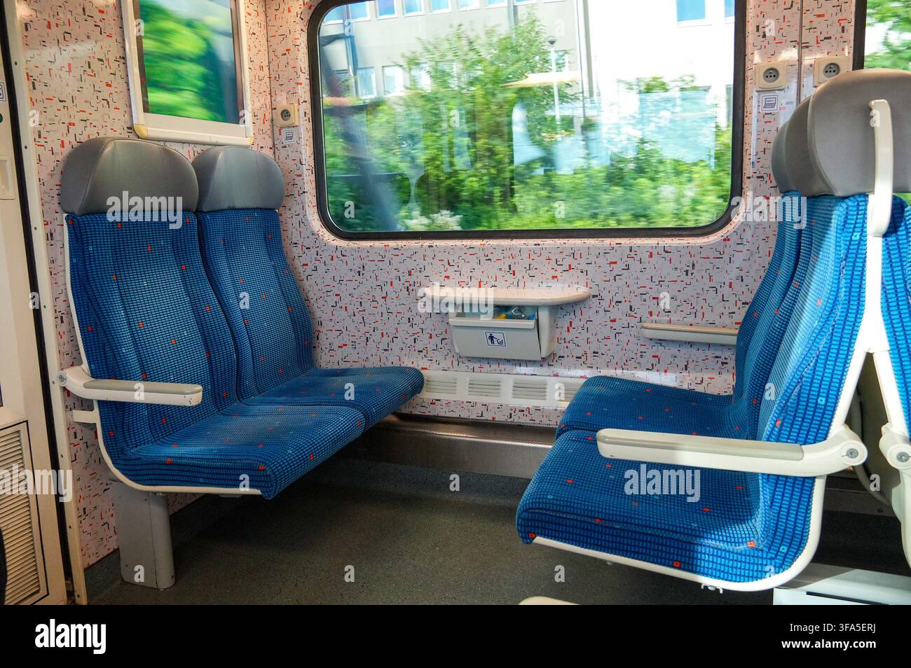 Intérieur d'un train avec des sièges bleus et un siège blanc. Banque D'Images