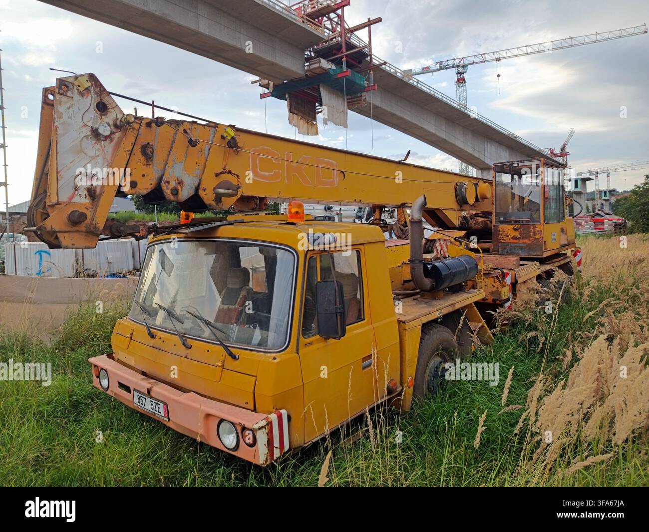 Trutnov, République tchèque – 5 août 2026. Un camion-crane jaune Tatra 815 CKD est garé dans une zone herbeuse. Le véhicule est rouillé et présente des signes d'usure. Banque D'Images