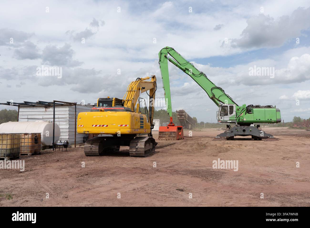 Machines industrielles lourdes et pelleteuses hydrauliques travaillant sur un chantier de construction ou dans une scierie Banque D'Images
