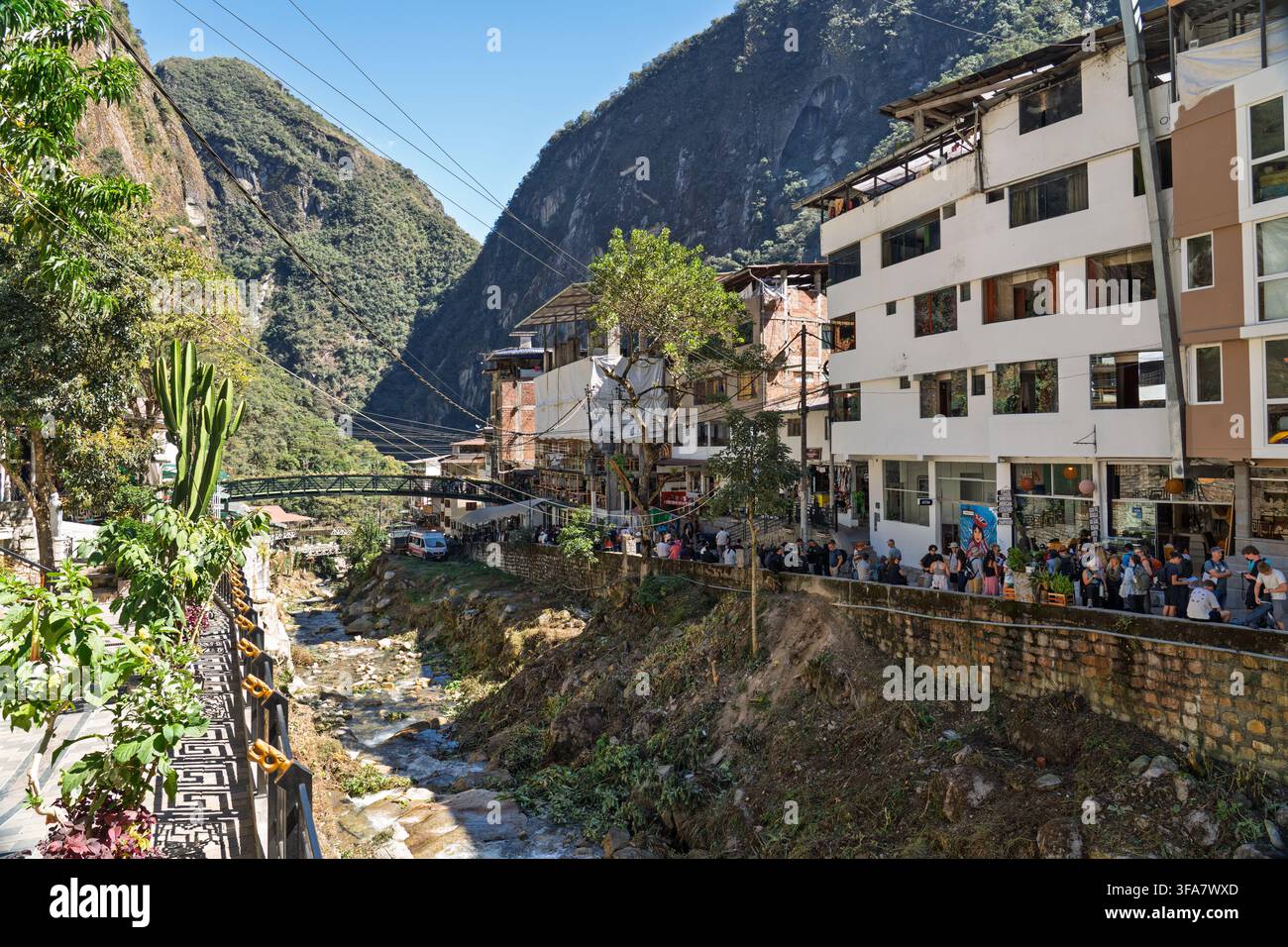 Touristes faisant la queue le long du canyon de la rivière Alcamayo à Aguas Calientes pour monter dans le bus en direction de la citadelle de Machu Picchu, Cusco, Pérou. Banque D'Images
