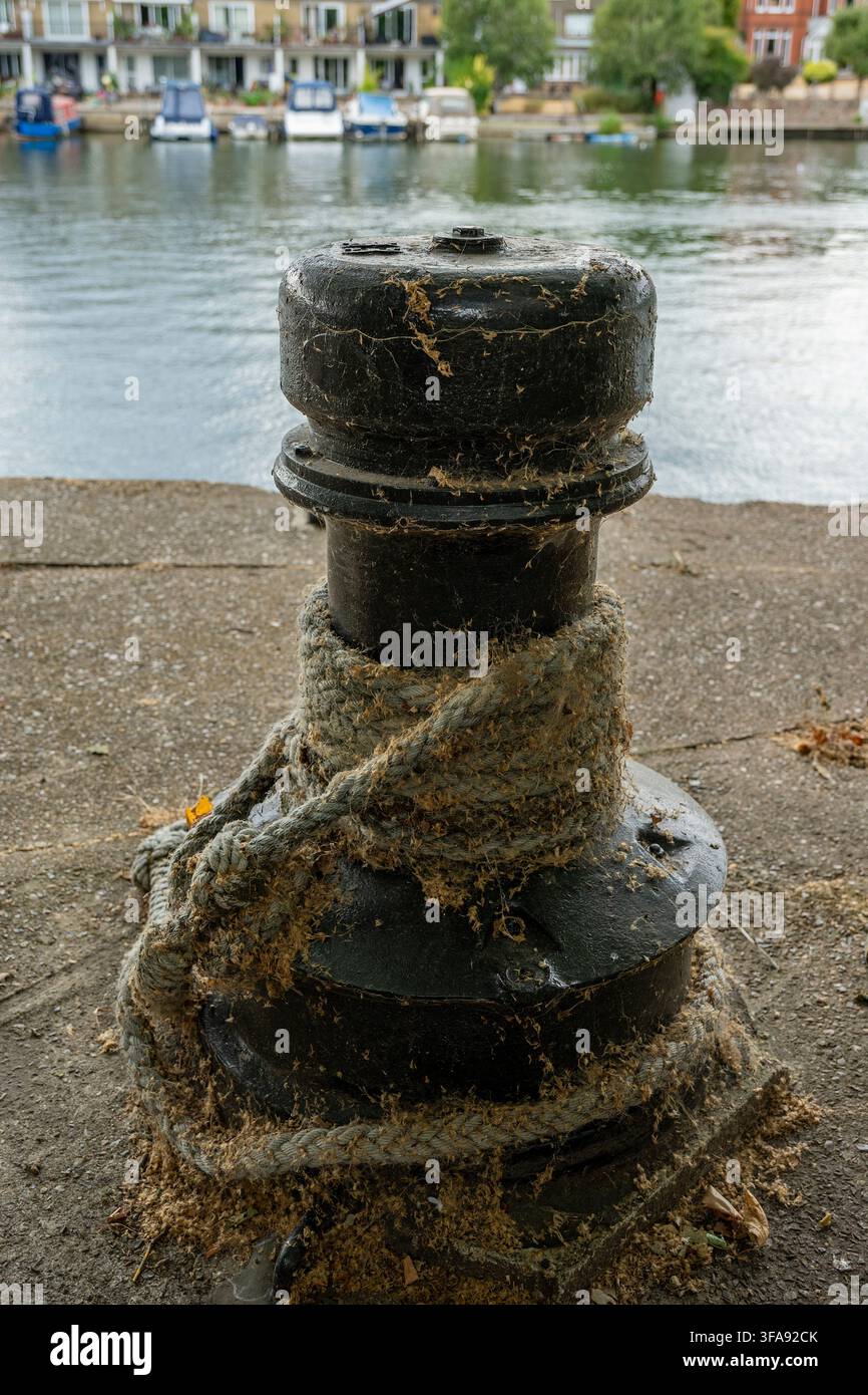 Ancienne poulie de quai et bittement d'amarrage avec une corde patinée autour, sur les berges de la Tamise à Kingston, Royaume-Uni Banque D'Images