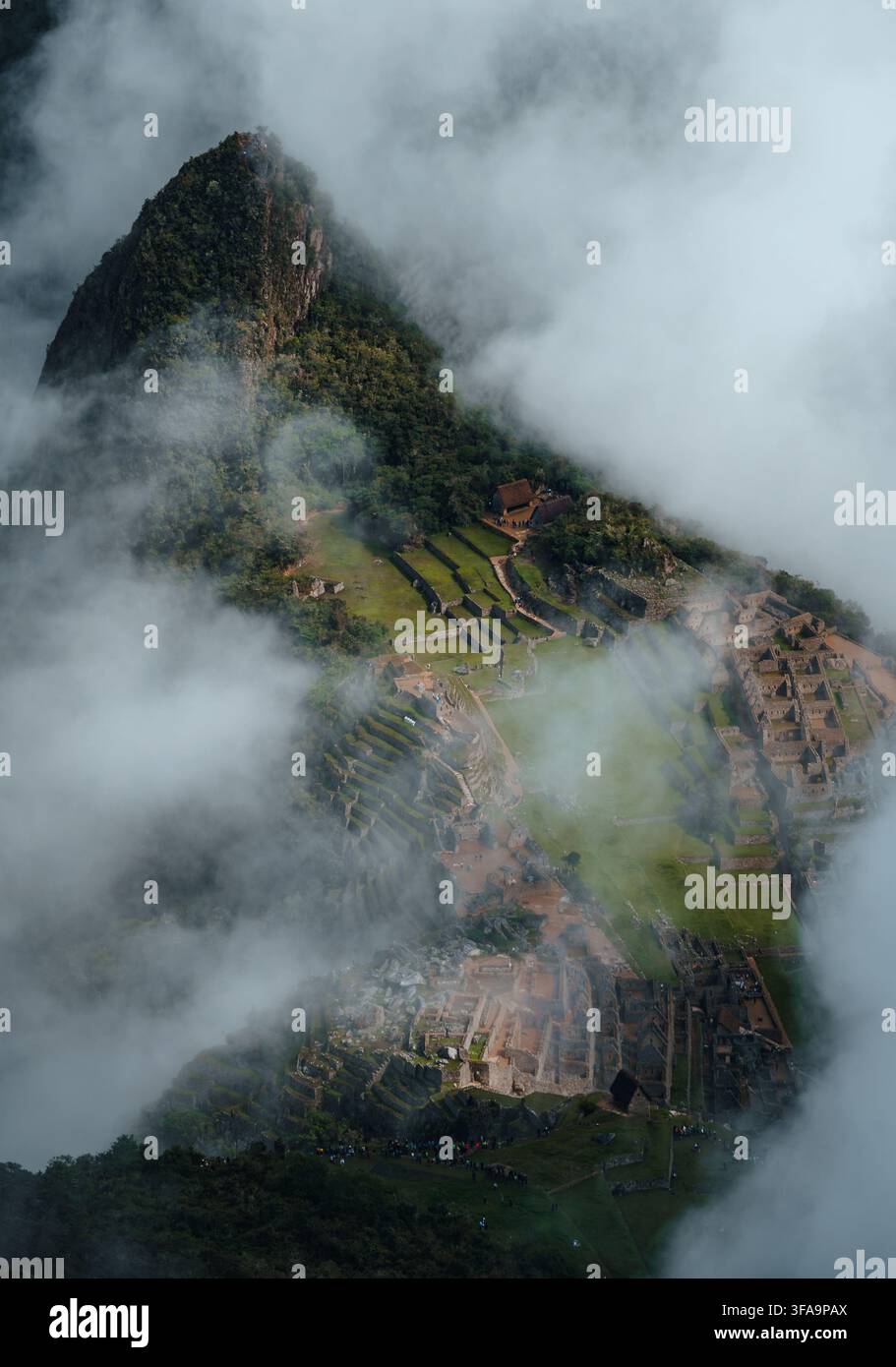 Vue aérienne détaillée de la citadelle de Machu Picchu nichée parmi les montagnes brumeuses des Andes, Pérou Banque D'Images