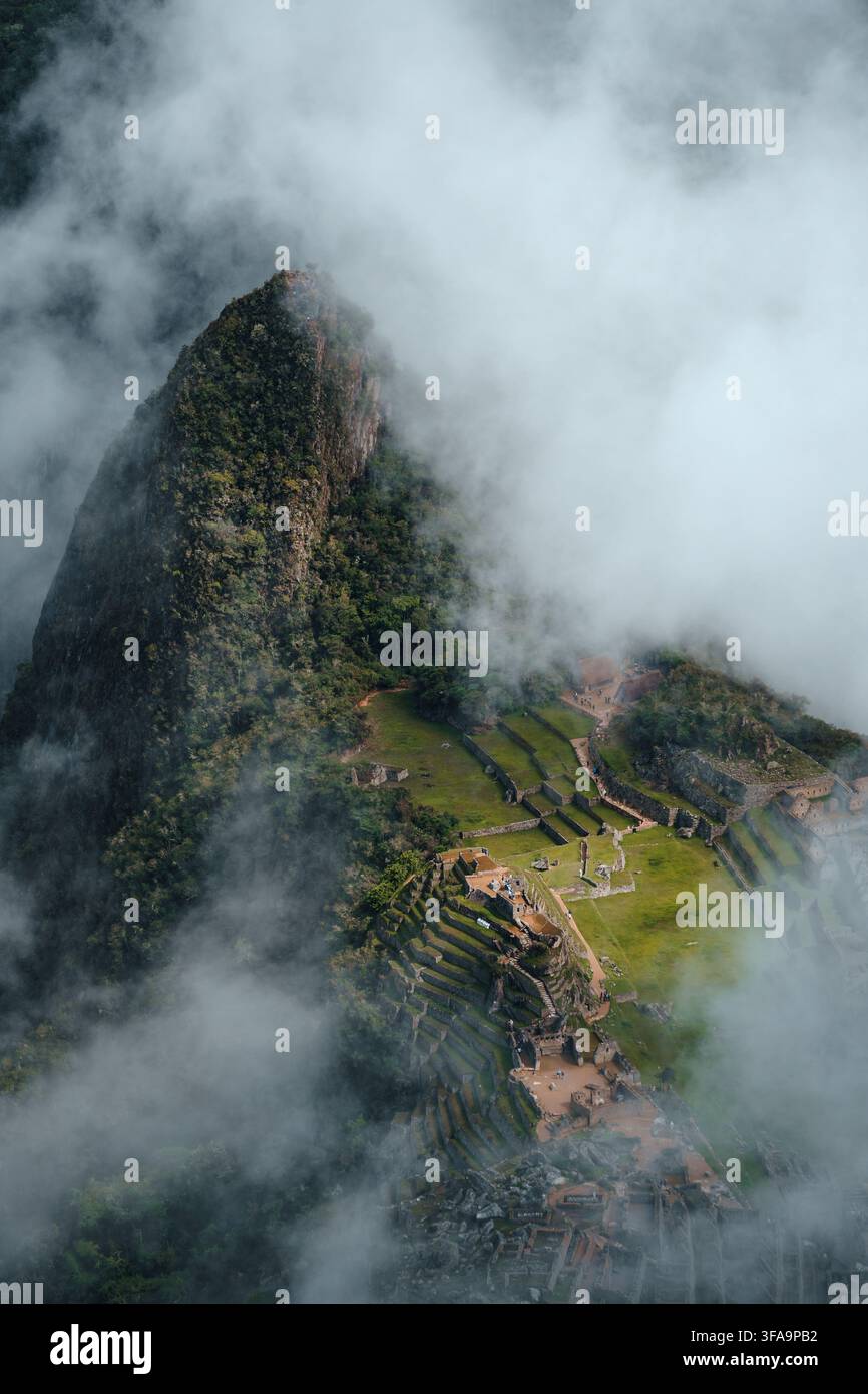 Vue aérienne détaillée de la citadelle de Machu Picchu nichée parmi les montagnes brumeuses des Andes, Pérou Banque D'Images