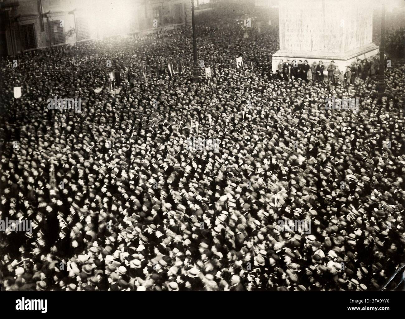 "Une foule immense s'est rassemblée sur la Piazza Colonna, à Rome, en Italie, lors des élections italiennes de 1929. La photographie documente la mobilisation politique de masse et le spectacle public entourant les premières élections parlementaires de l'Italie fasciste sous le nouveau système électoral introduit par le régime fasciste. La Piazza Colonna était également un cadre prominent pour les cérémonies et les rassemblements politiques fascistes pendant cette période." Banque D'Images