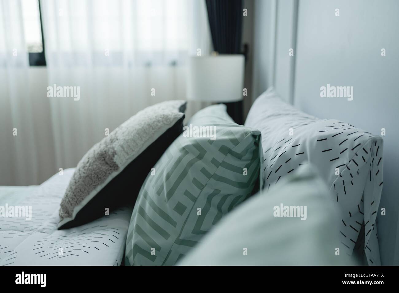 Les coussins modernes et l'arrangement apaisant de la parure de lit ainsi que la palette de couleurs rendent le cadre idéal pour une détente et une paix. Banque D'Images