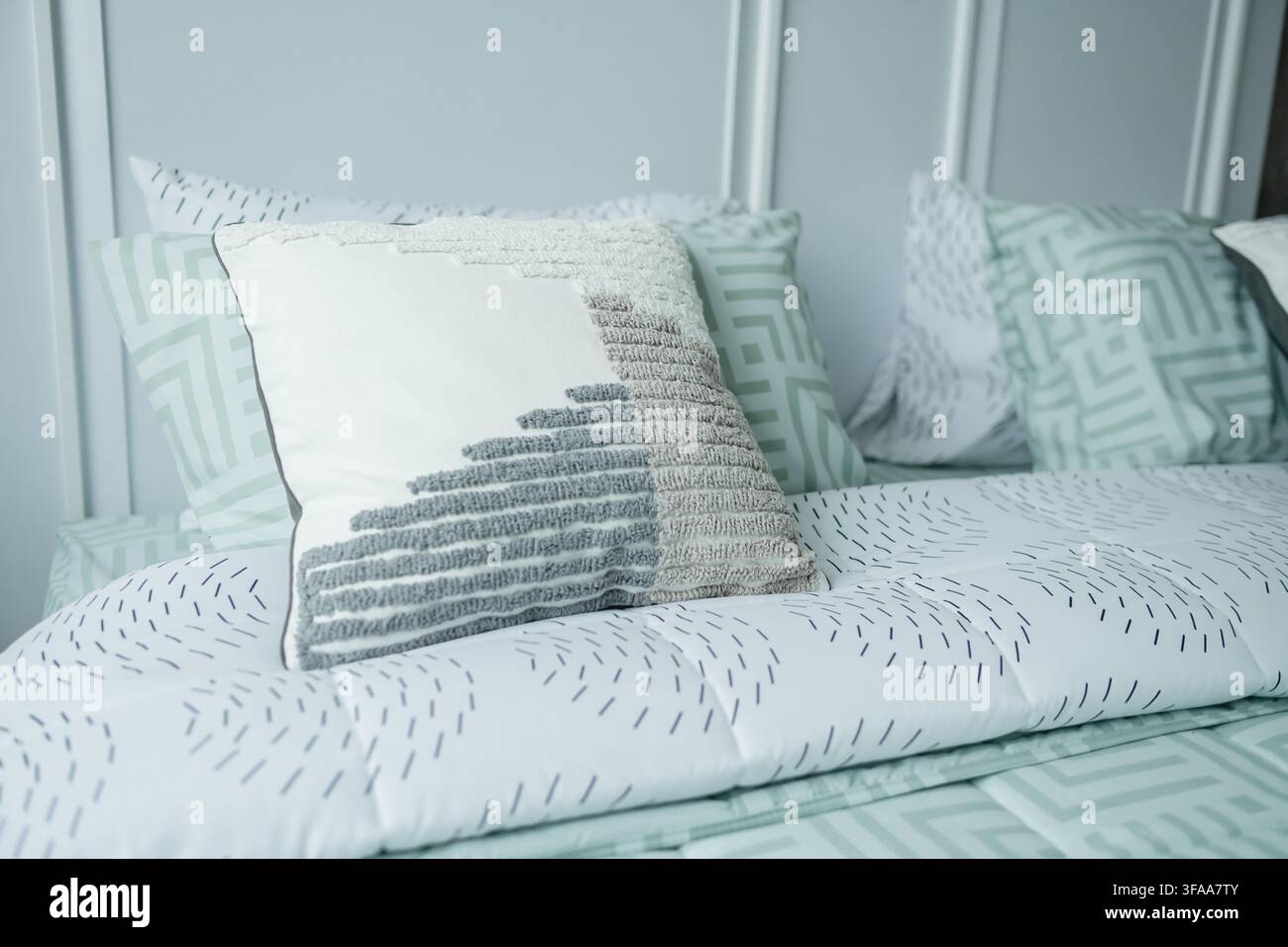 Les coussins modernes et l'arrangement apaisant de la parure de lit ainsi que la palette de couleurs rendent le cadre idéal pour une détente et une paix. Banque D'Images