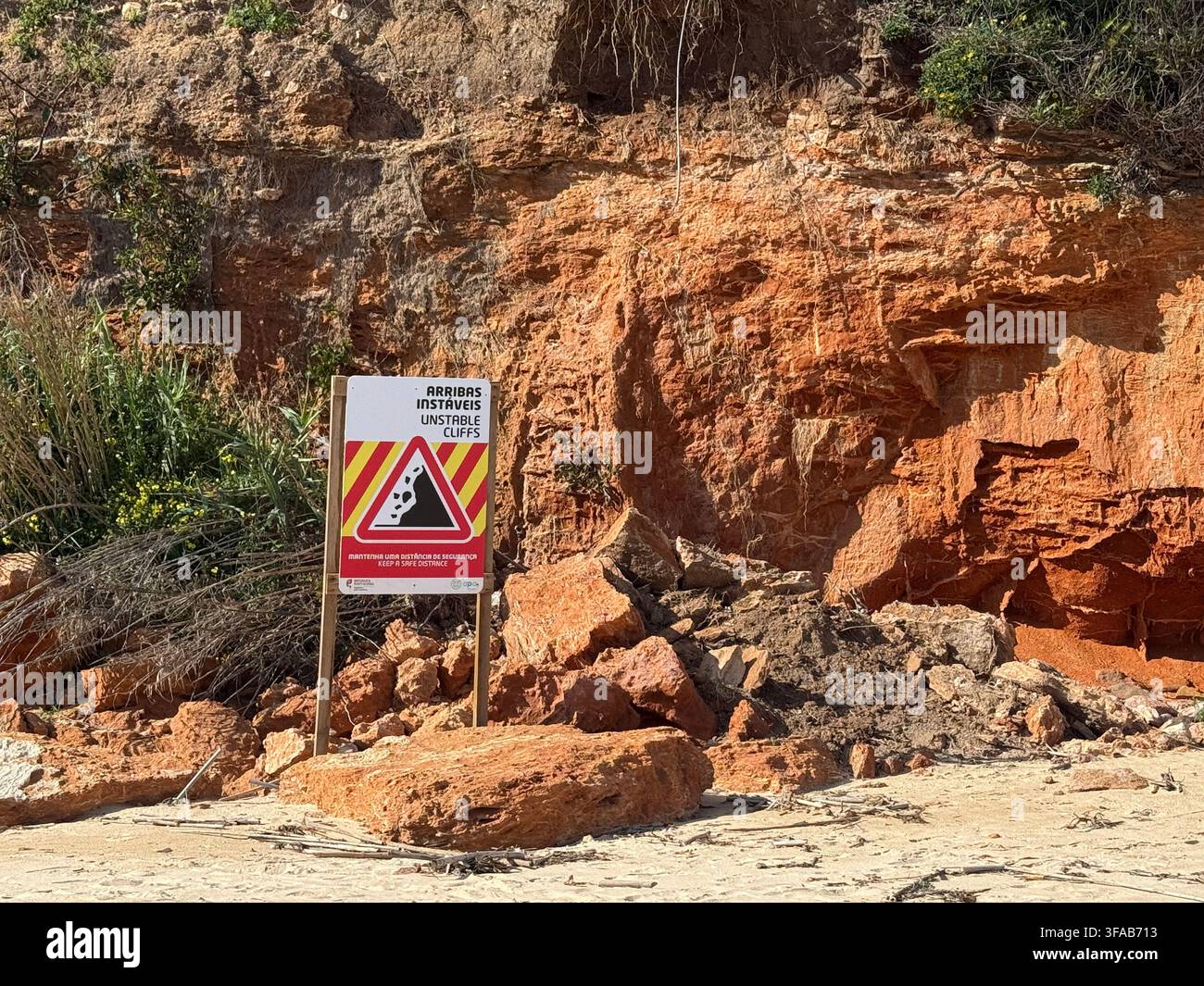 ALGARVE, PORTUGAL - avril 2025 : Un panneau d'avertissement alerte les visiteurs sur les falaises instables et le risque d'éboulement le long d'une paroi rocheuse côtière érodée. - Image de stock capturée avec un smartphone