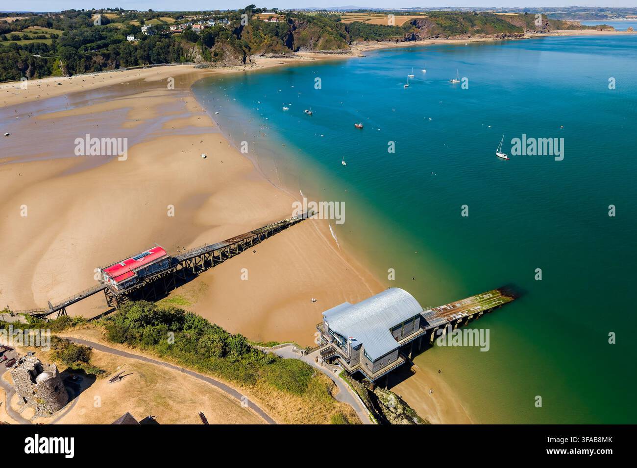 Anciennes et nouvelles stations de sauvetage de Tenby surplombant North Beach à marée basse, vaste baie de sable rencontrant les eaux côtières turquoise du Pembrokeshire, au Pays de Galles Banque D'Images