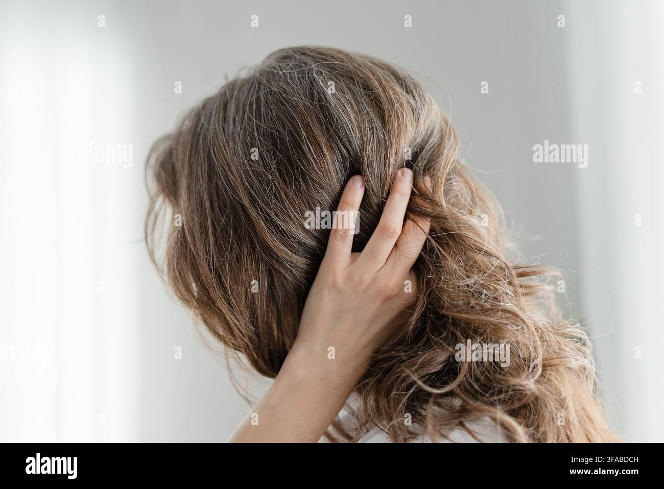 Une femme célèbre sa couleur naturelle de cheveux qui comprend de magnifiques mèches grises. L'adulte mûre refuse de teindre et embrasse complètement l'authenticité. La mère adore les véritables mèches argentées Banque D'Images