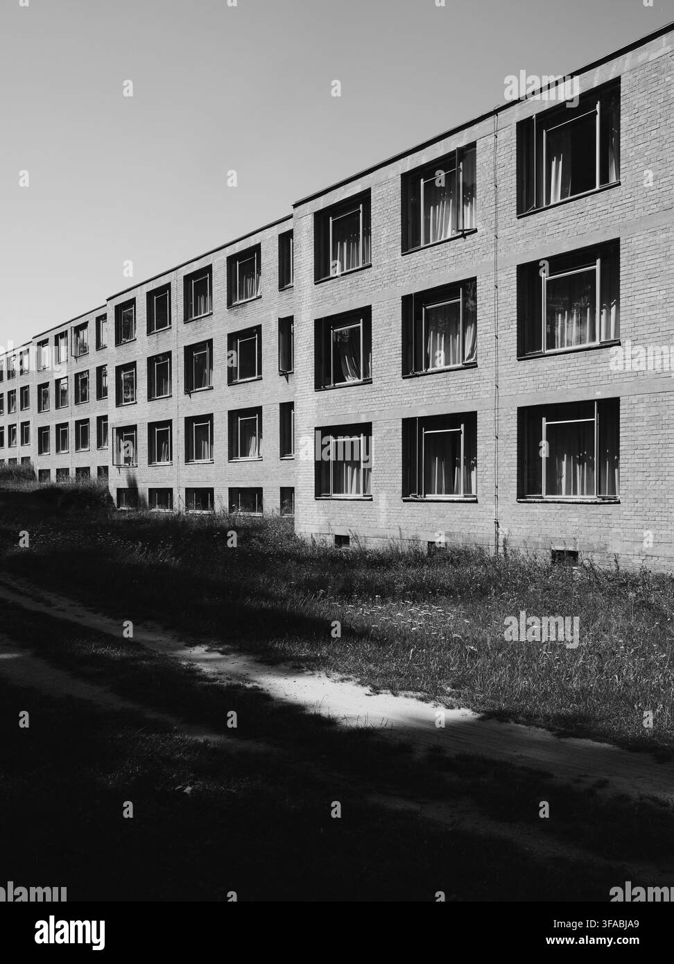 Un plan extérieur monochrome d'un grand complexe d'appartements ou d'un bâtiment d'hôpital en brique avec un motif géométrique répétitif de fenêtres. Banque D'Images