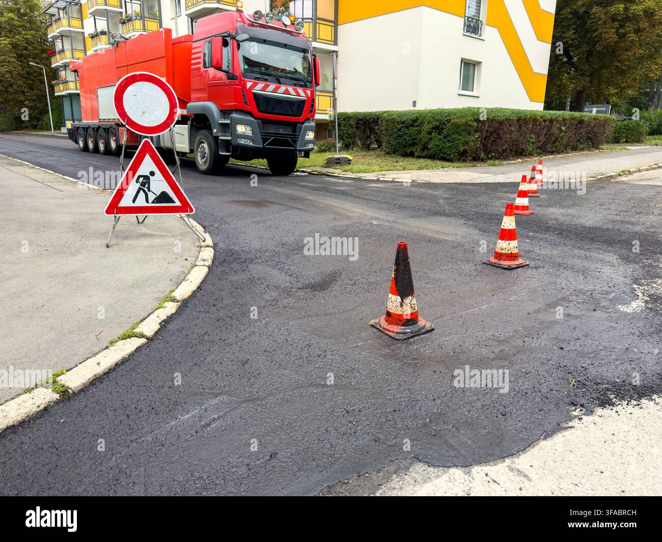Surface d'asphalte noir fraîche sur une route urbaine rénovée – Chantier de construction Banque D'Images