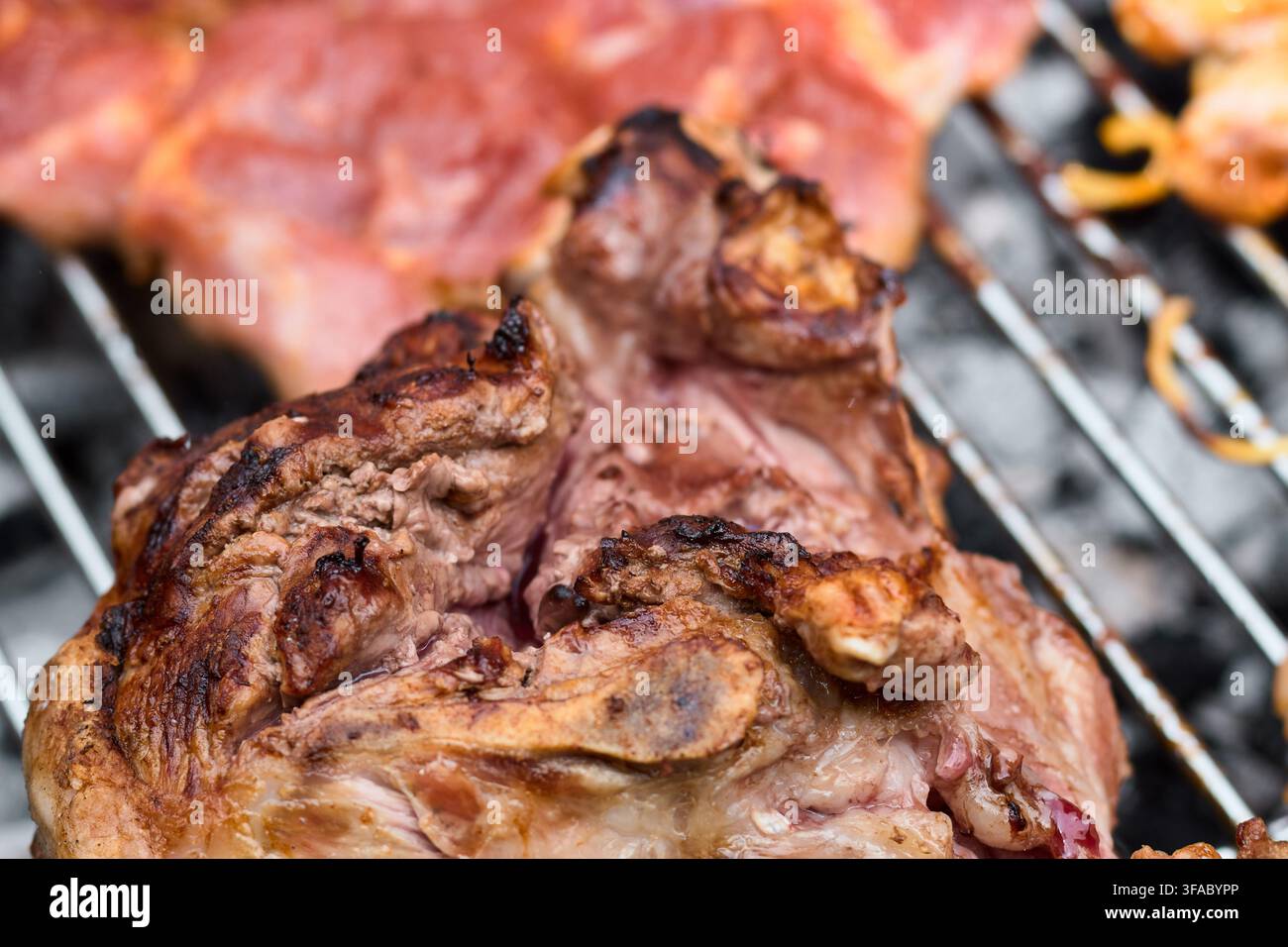 Close-up détaillé de viande d'agneau rôtie savoureuse cuisant sur une grille métallique de barbecue au-dessus d'un charbon de bois chaud avec une texture grillée juteuse préparée pour un repas délicieux Banque D'Images