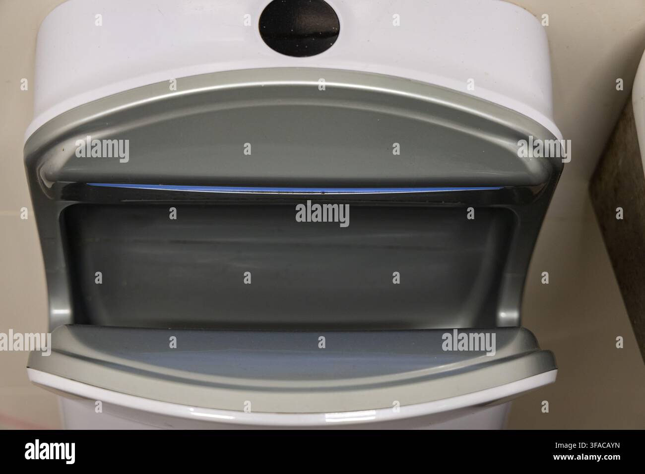 Une vue rapprochée d'un sèche-mains automatique contemporain, mettant en évidence ses lignes épurées et son design fonctionnel pour un séchage efficace des mains dans les espaces commerciaux Banque D'Images
