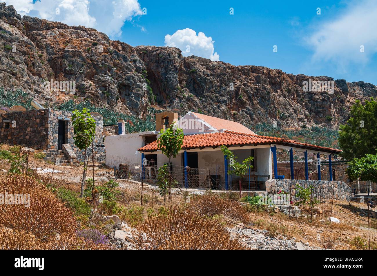 Une petite chapelle traditionnelle blanche avec un toit en tuiles rouges et un clocher, située sur l'île de Gramvousa à Crète, Grèce. Banque D'Images