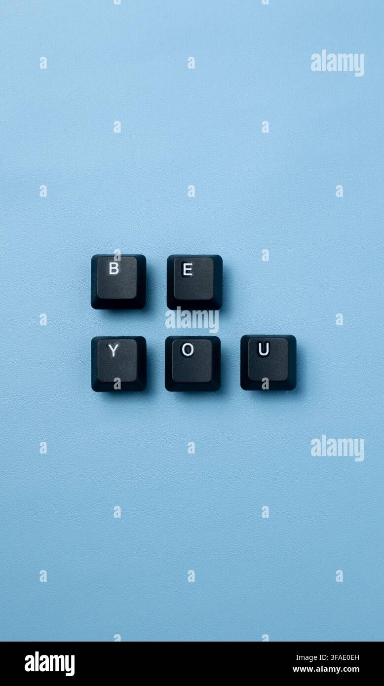 Texte "Be You" créé à partir de touches de clavier sur un fond bleu, représentant l'authenticité, la confiance, l'individualité, l'encouragement Banque D'Images