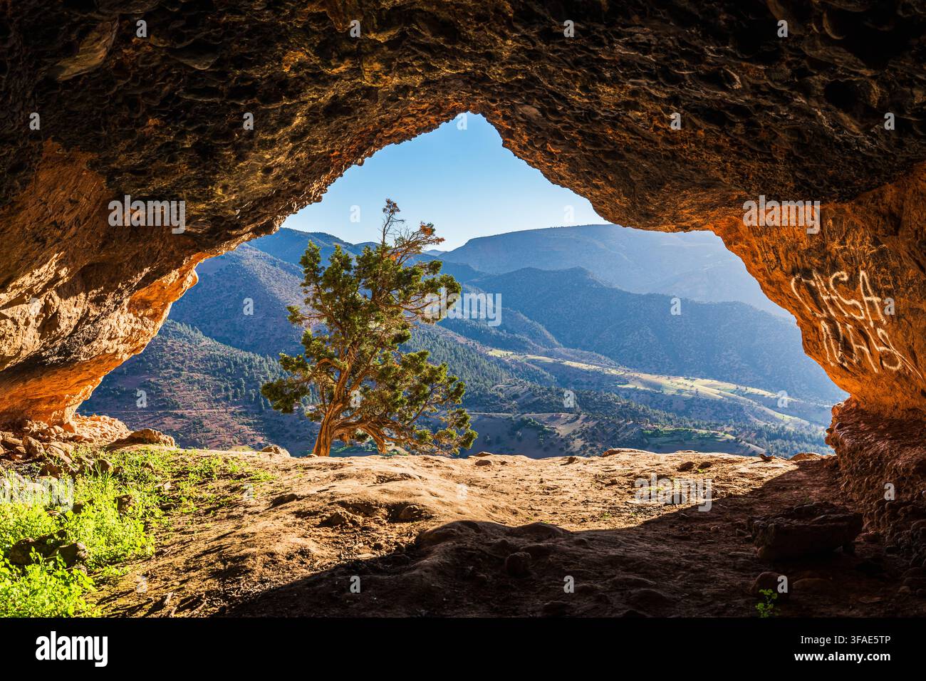 Vallée montagneuse pittoresque et sommets des Monts Atlas encadrés par une grotte rocheuse naturelle au sommet d'Imsefrane, au Maroc. Banque D'Images