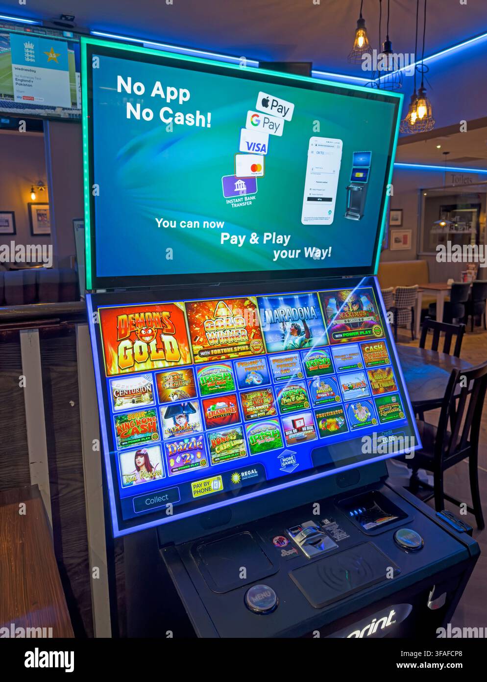 Machine de jeu de pub promouvant le jeu en espèces, par carte ou via une application, illustrant l'accès facile aux jeux d'argent et les dommages potentiels liés à la dépendance dans les lieux de tous les jours. Banque D'Images