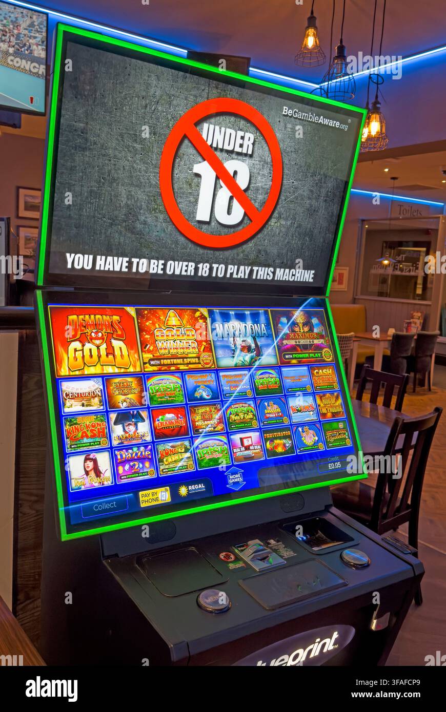 Machine de jeu pour plus de 18 ans dans un pub, soulevant des questions sur la vérification de l'âge, la supervision et l'accès aux jeux d'argent dans les établissements autorisés. Banque D'Images