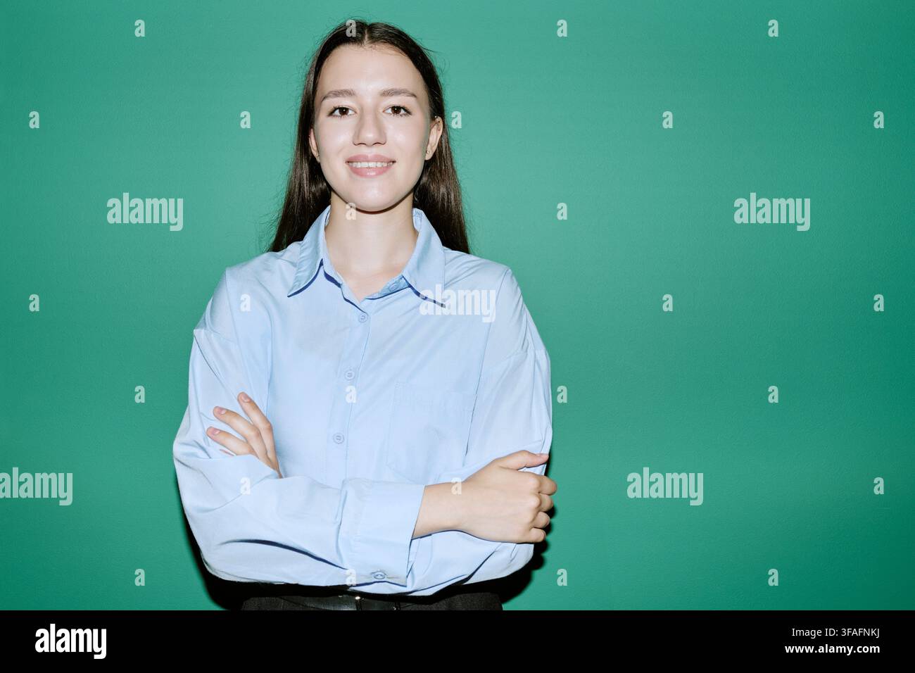 Portrait d'une étudiante souriante debout les bras croisés Banque D'Images