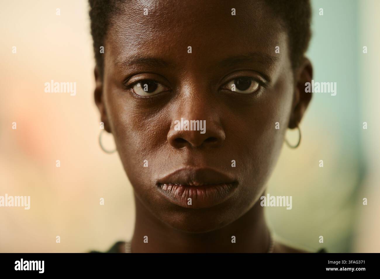 Portrait d'une jeune femme afro-américaine regardant directement l'appareil avec une expression sérieuse. L'image représente le bien-être mental et convient aux campagnes de santé, gros plan extrême Banque D'Images