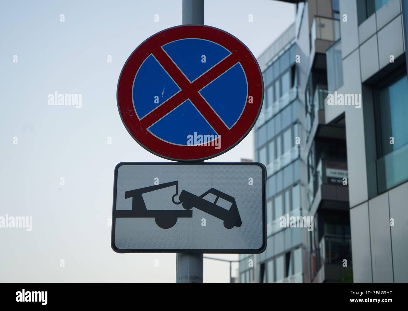 Vue rapprochée d'un panneau de signalisation "Pas d'arrêt" avec plaque de zone de remorquage au crépuscule Banque D'Images