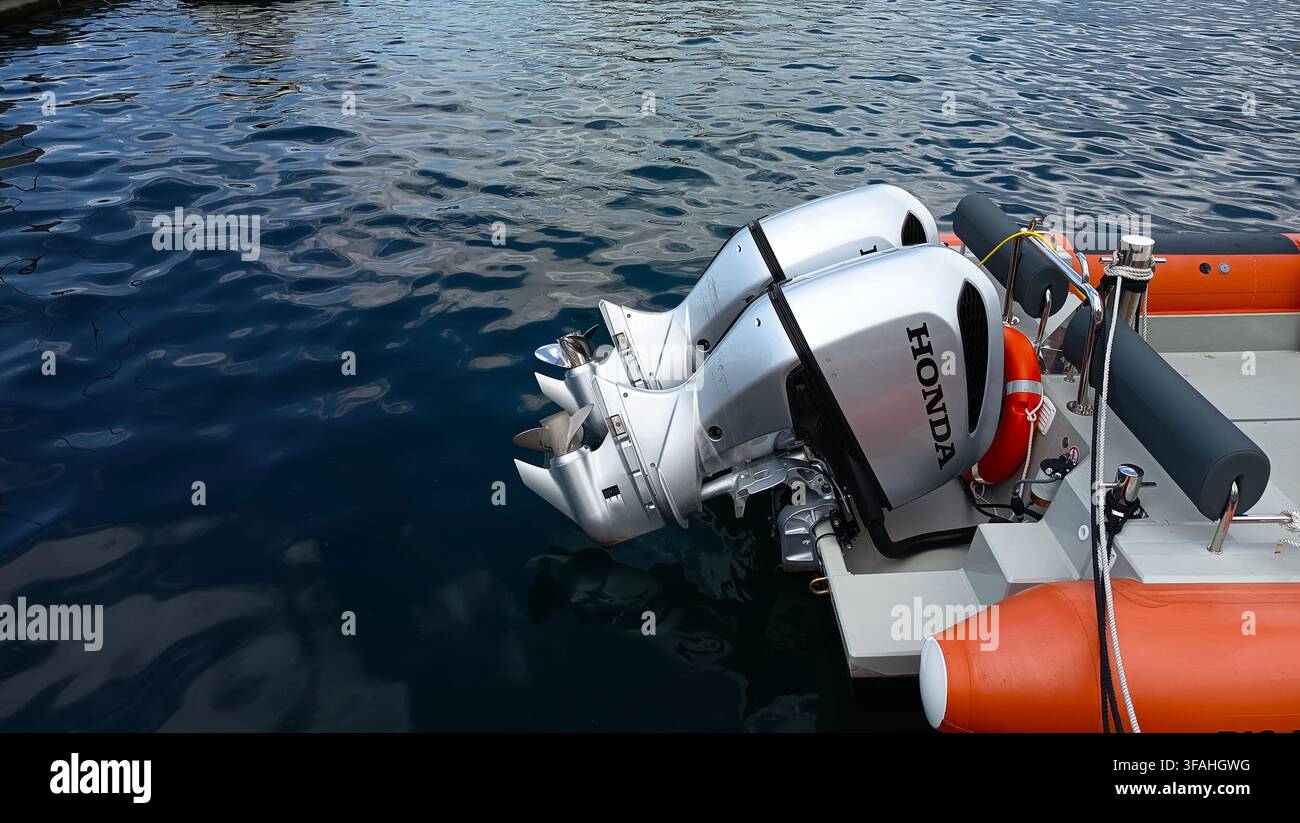 Moteurs hors-bord jumeaux Honda montés sur un bateau à moteur RIB orange flottant sur l'eau bleue de la mer dans le port de Rijeka, baie de Kvarner, Croatie. Banque D'Images