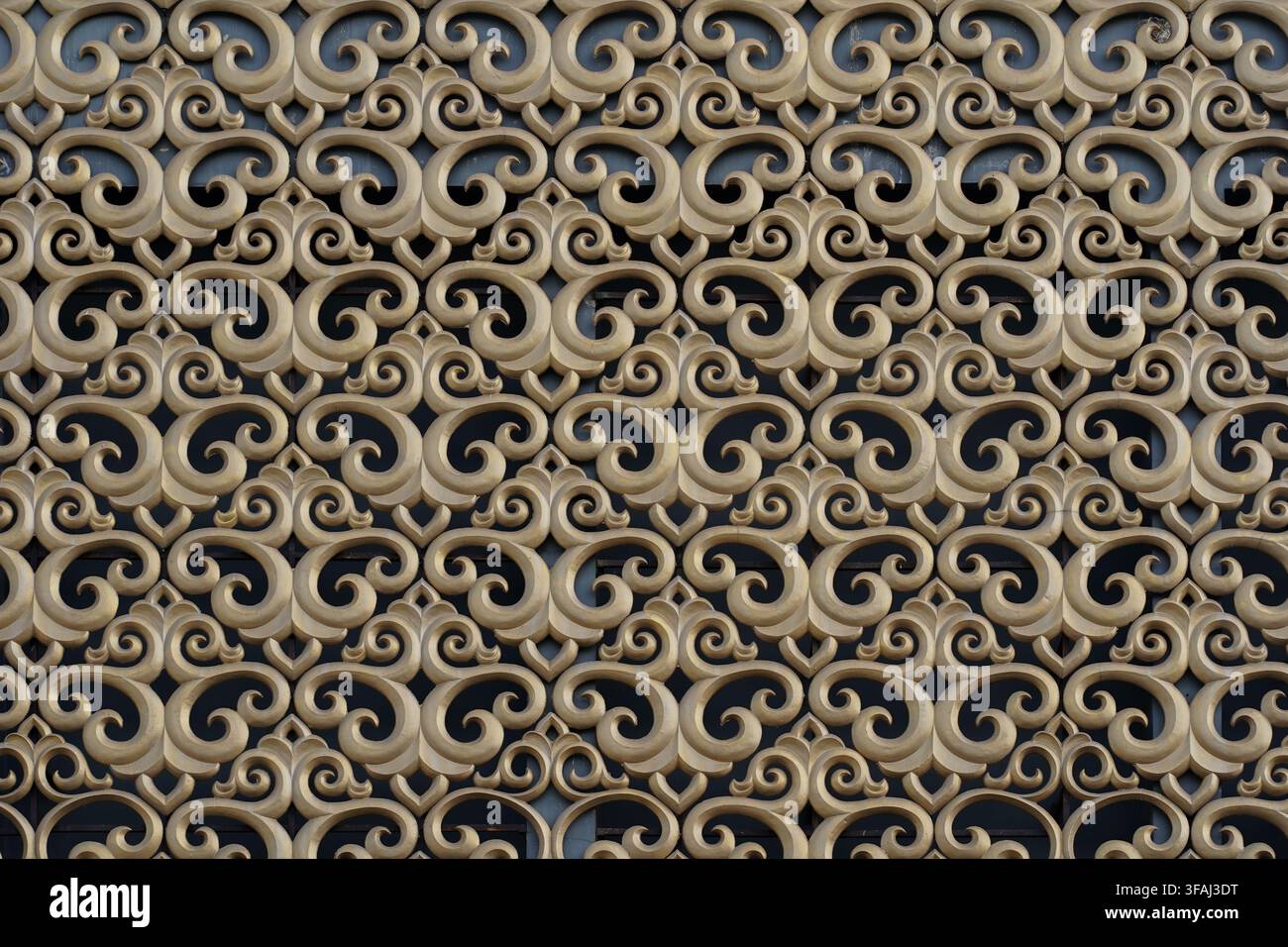 Gros plan détaillé d'une sculpture architecturale ornée de motifs en spirale et floraux répétitifs. Un motif décoratif traditionnel sans couture. Banque D'Images