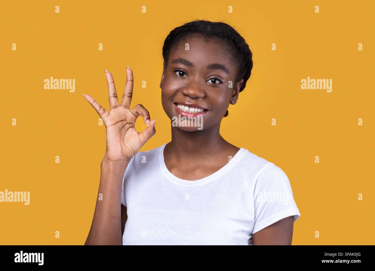 Positive Black Woman gestante OK posant sur fond jaune Banque D'Images