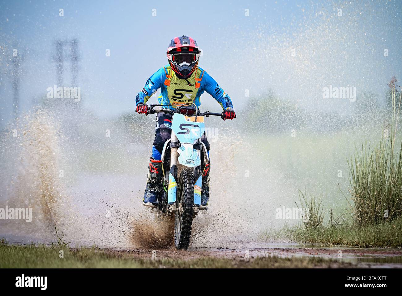 Conducteur de moto tout-terrain électrique sur une piste boueuse hors route. Banque D'Images