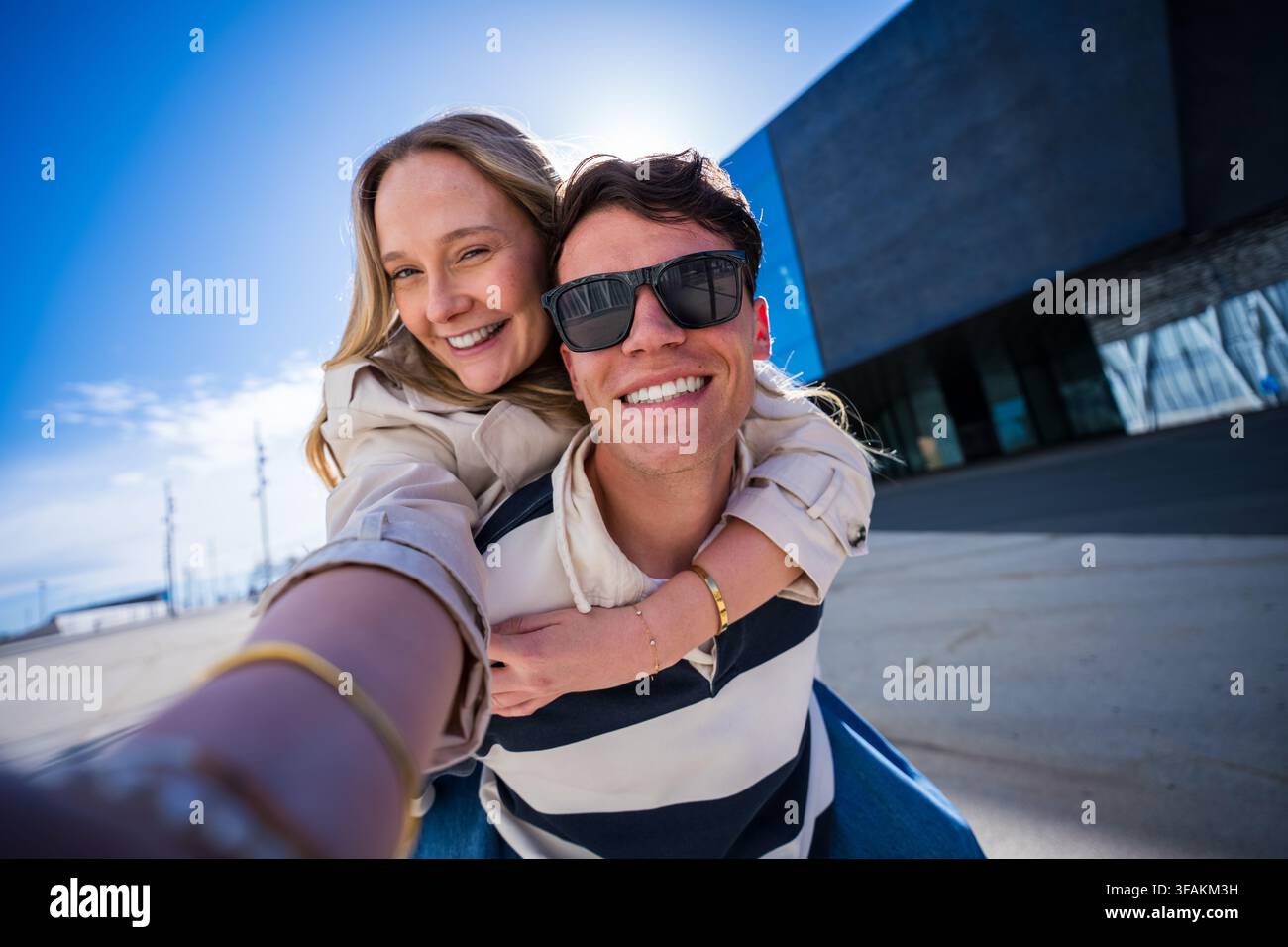Jeune couple joueur prenant un selfie tout en profitant d'un tour à califourchon sur l'extérieur Banque D'Images