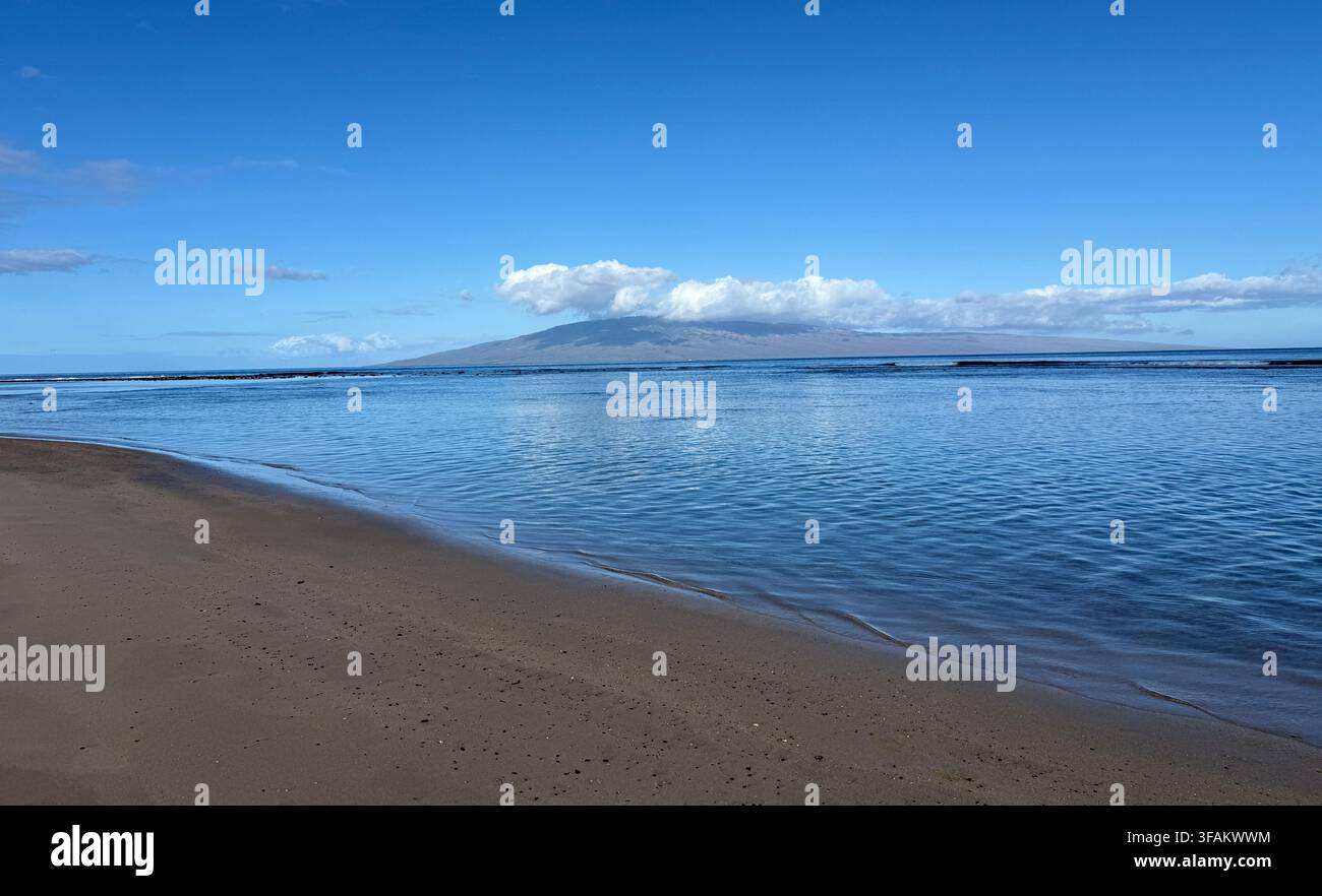 Côte de sable et Pacifique calme avec Lanai visible au loin sur Maui, Hawaï. - Image de stock capturée avec un smartphone