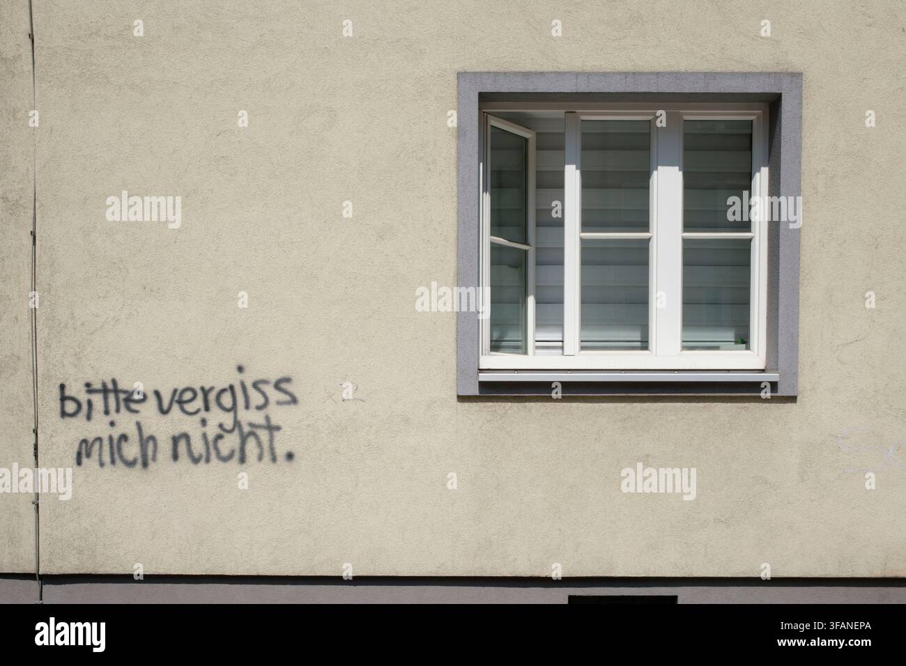 Un mur de bâtiment avec le graffiti écrit à la main S'IL VOUS PLAÎT NE M'OUBLIEZ PAS à côté d'une fenêtre ouverte. Banque D'Images