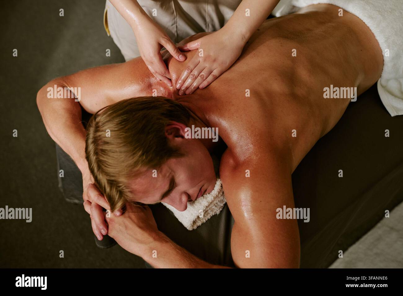 Homme recevant un massage relaxant du dos dans un salon de spa bien-être Banque D'Images