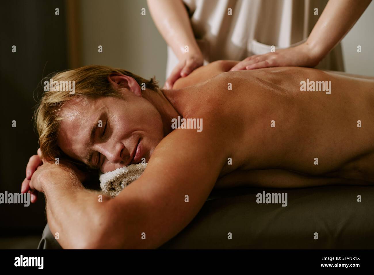 Homme recevant un massage du dos d'un thérapeute dans un salon de spa bien-être Banque D'Images