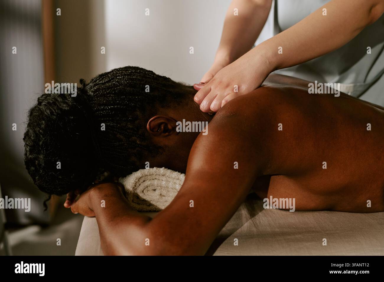 Femme noire recevant un massage professionnel du dos dans un spa Banque D'Images