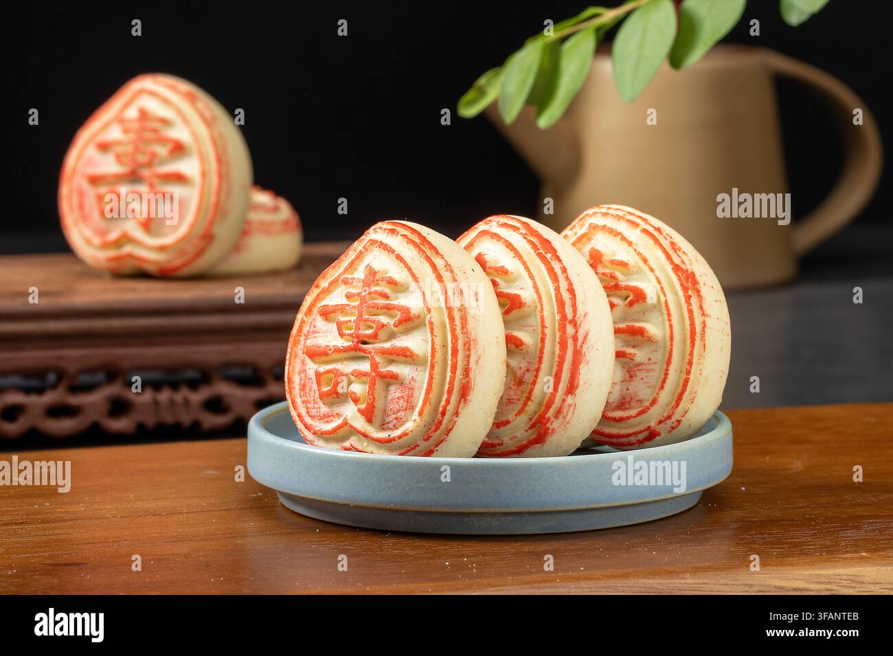Gâteau de lune chinois traditionnel en forme de pêche de longévité avec des caractères propices Banque D'Images
