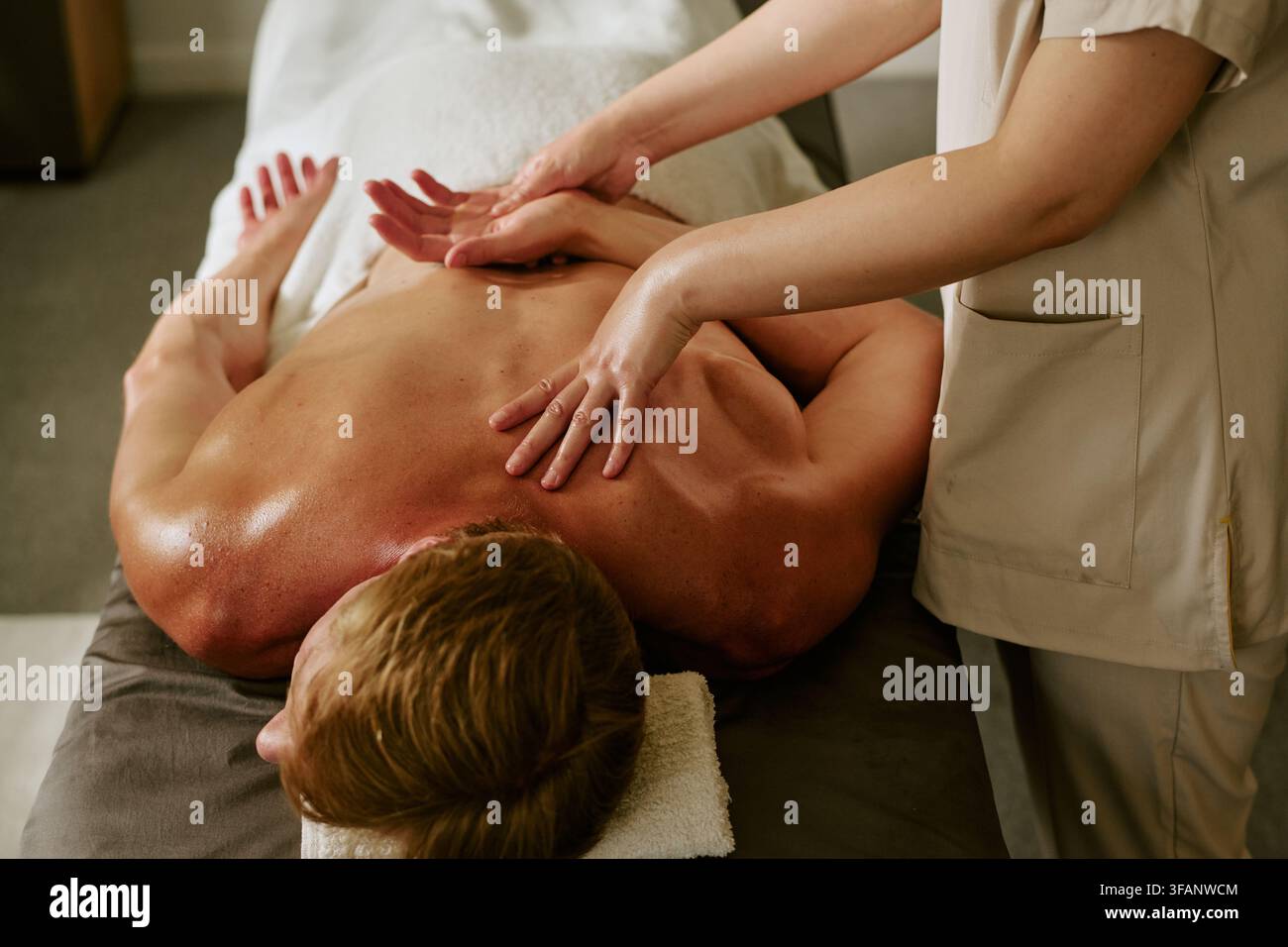 Thérapeute massant le dos d'un homme dans un spa bien-être Banque D'Images