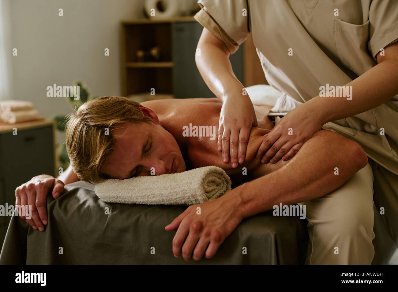 Homme recevant un massage professionnel des épaules dans un spa bien-être Banque D'Images