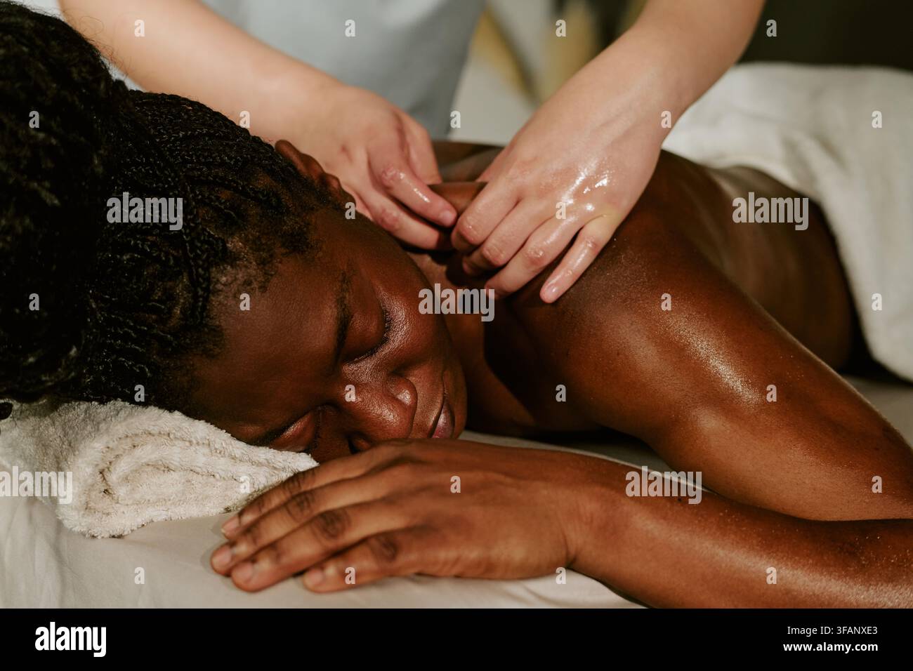 Femme noire recevant un massage des épaules d'un thérapeute dans un spa Banque D'Images