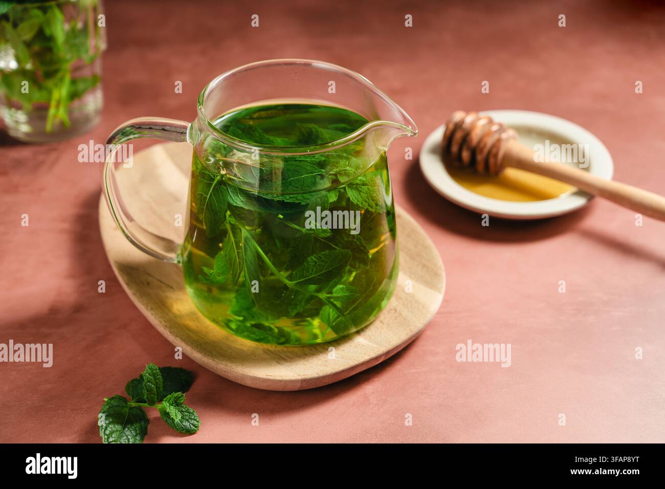 Thé à la menthe frais dans une théière en verre transparent, boisson aux herbes maison Banque D'Images