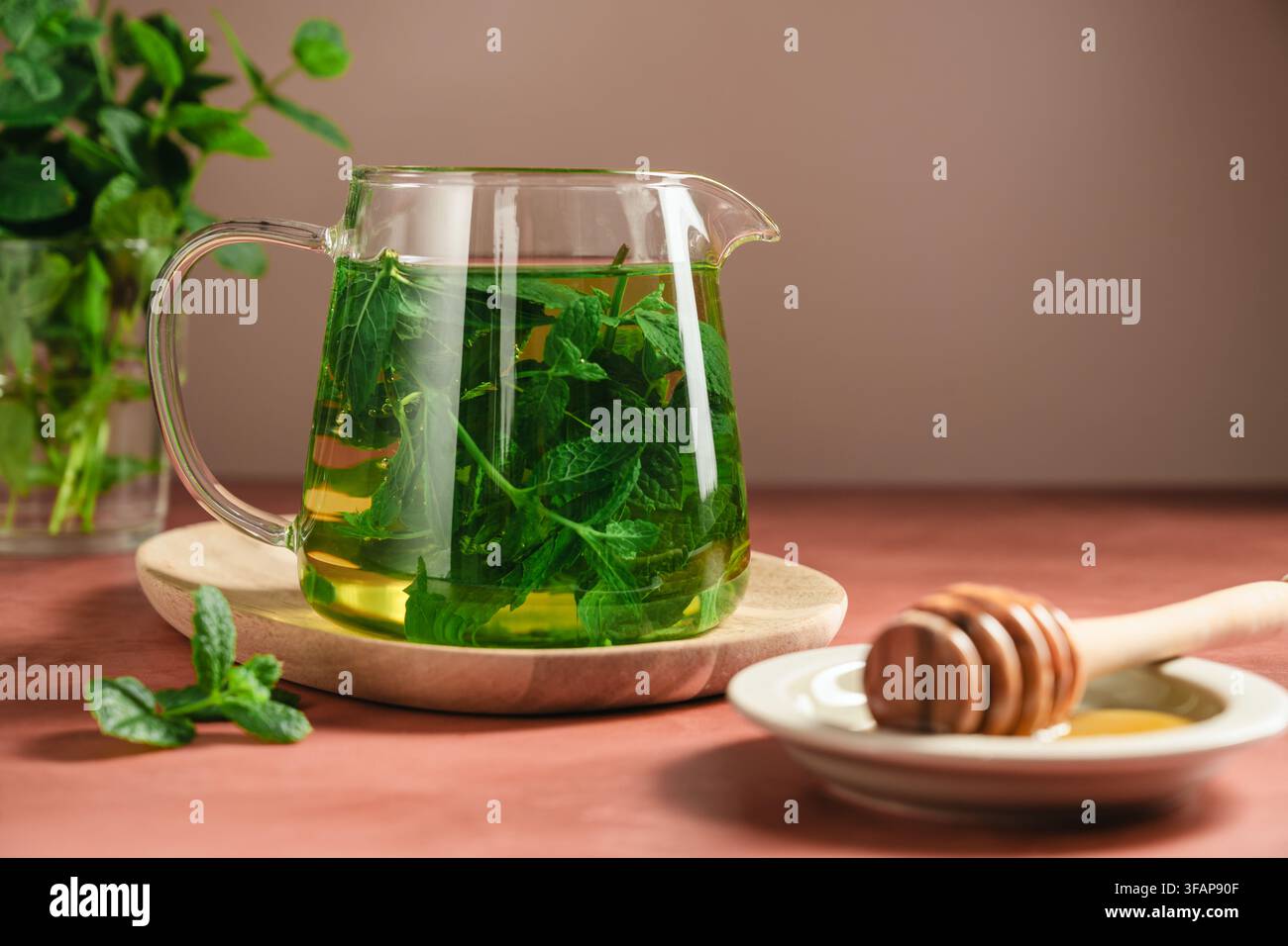 Thé à la menthe frais dans une théière en verre transparent, boisson aux herbes maison Banque D'Images