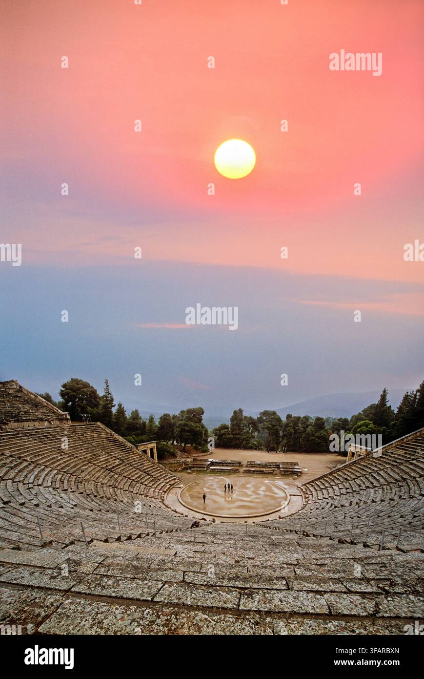 Les visiteurs explorent l'ancien théâtre du sanctuaire d'Asclépios au coucher du soleil en Grèce Banque D'Images