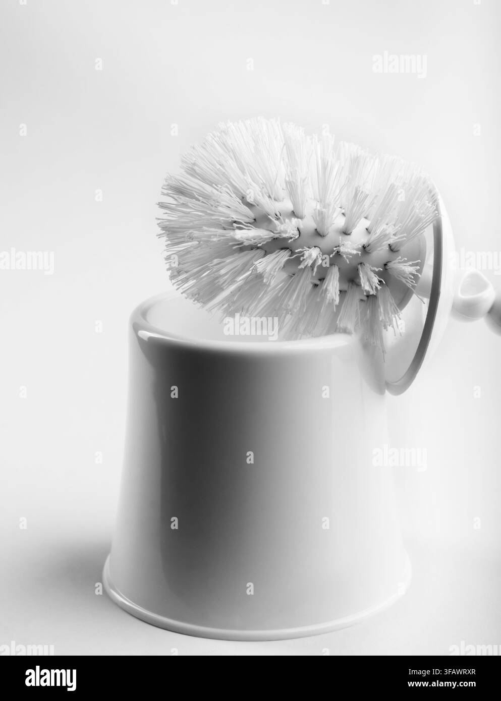 Brosse de toilette blanche dans un porte-gobelet propre isolé sur fond blanc, accessoire d'hygiène et de sanitation de salle de bain. Banque D'Images