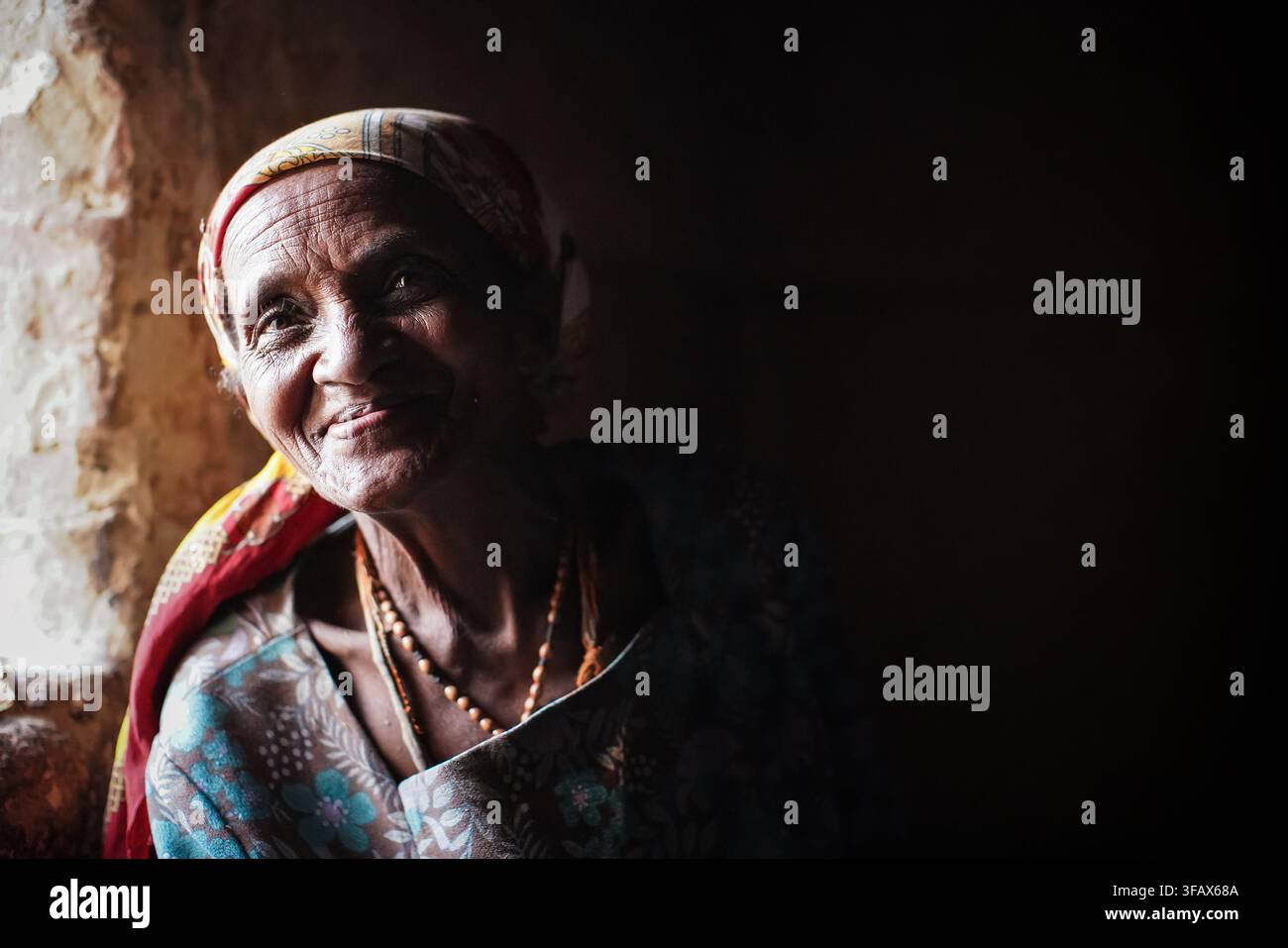 Ivato, Madagascar – 26 avril 2019 : Ancien femme malgache locale posant dans sa maison près de la fenêtre, portrait en gros plan. Les gens ici sont pauvres mais joyeux Banque D'Images